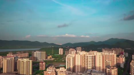 Slow-camera-panning-of-a-city-with-some-skyscrapers-and-mountains-in-the-background-with-a-blue-sky