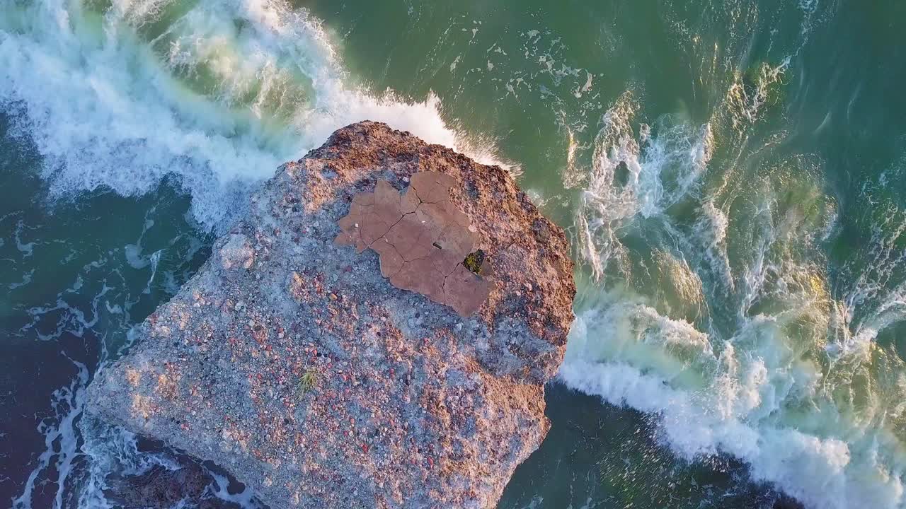 vista aérea a vista de pájaro de los edificios fortificados abandonados a la orilla del mar en karosta, fuertes del norte en la playa del mar báltico, salpicaduras de olas, puesta de sol de la hora dorada, disparos de drones bajos y anchos