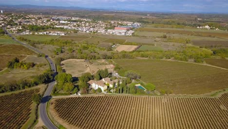 Vista-Aérea-De-Drones-De-Una-Finca-Rodeada-Por-Una-Carretera-Y-Campos-Con-Una-Ciudad-Al-Noroeste