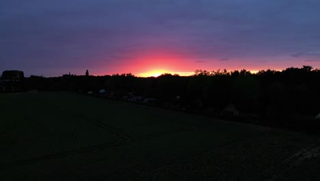 Goldener-Orangefarbener-Sonnenunterganghimmel-Mit-Schattenbildlandschaftsansicht