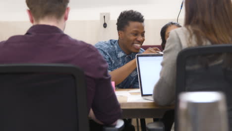 Male And Female Colleagues Smiling Together In Office