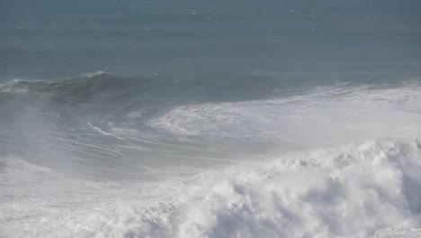 massive waves crashing onto the shore of nazare, portugal, showcasing nature's power