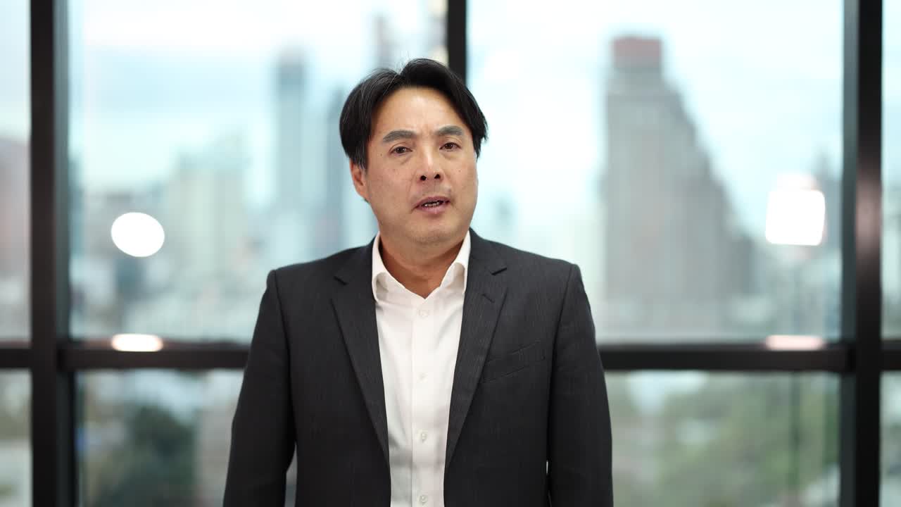 Businessman displays confidence, disapproval, and excitement with gestures in bright, city-view office