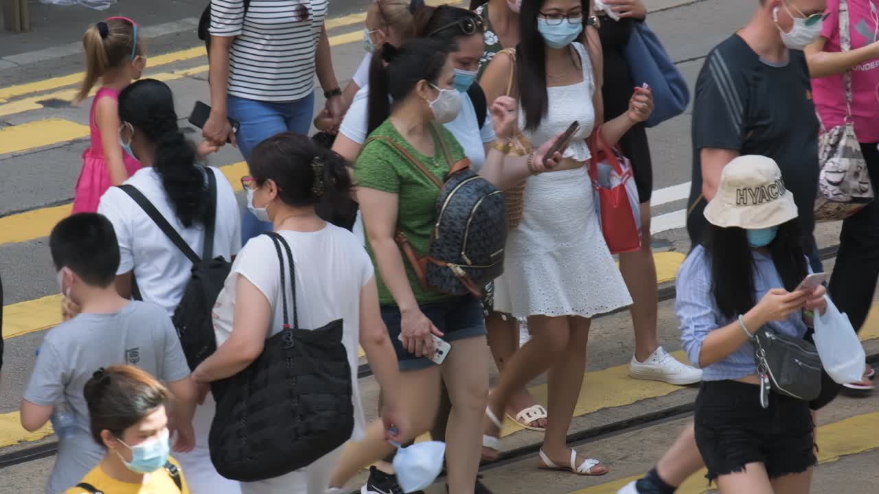 Hong Kong - July 5, 2020: Slow motion of crowd people wearing medical face masks in Hong Kong. Coronavirus concept.