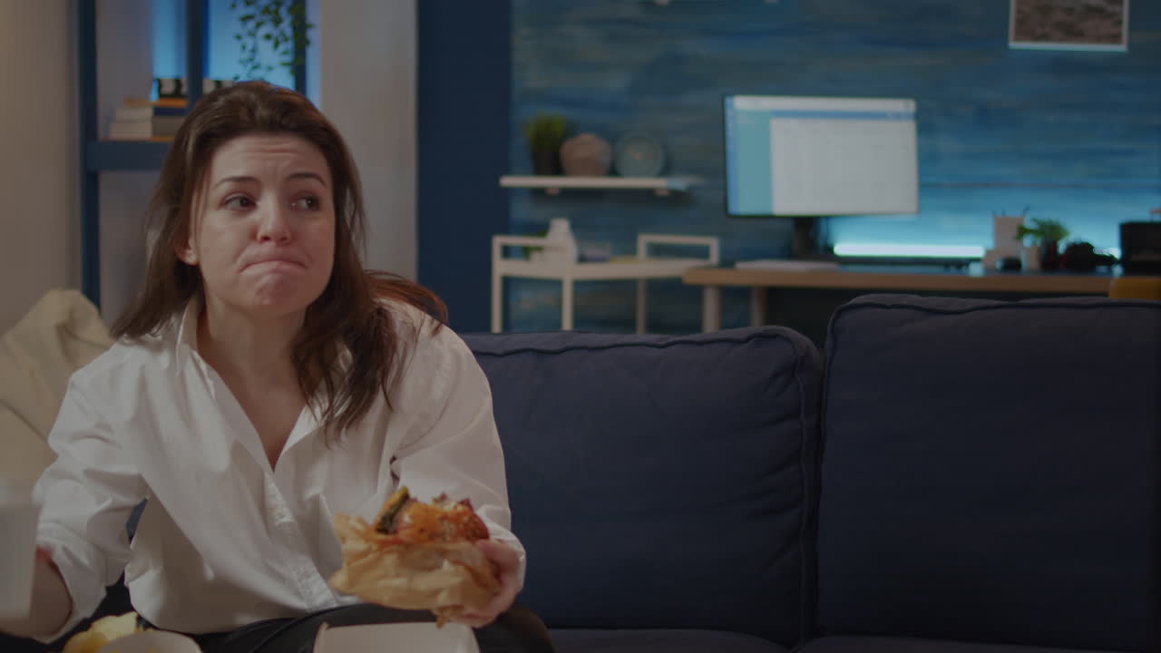 Caucasian woman taking bite from burger and sip of soda