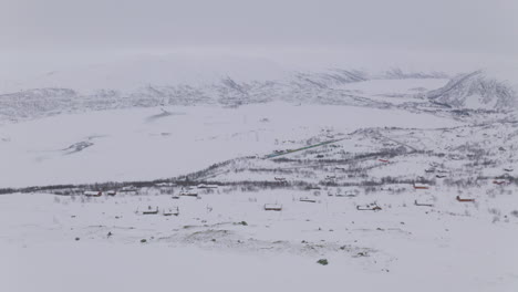 houses, hills, and mountains covered with snow at wintertime in haugastol, norway