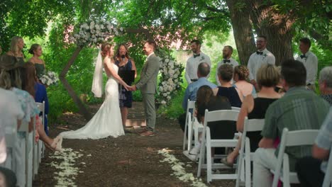 bride and groom standing at altar in outdoor forest ceremony, holding hands in slow motion