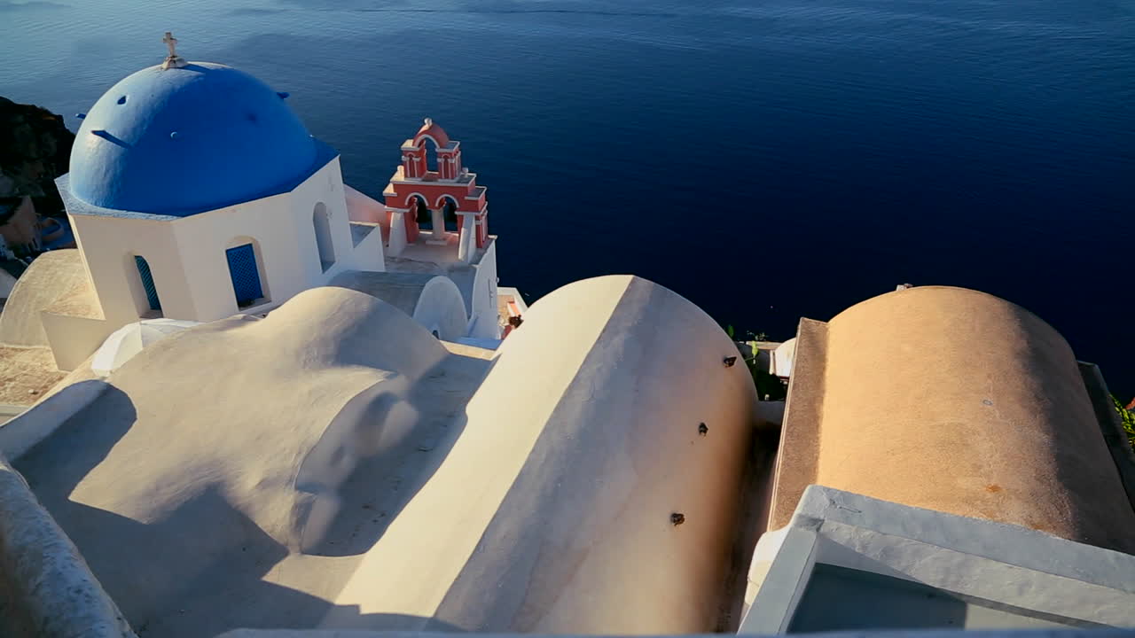 una hermosa cacerola lenta de una iglesia ortodoxa griega en la isla griega de santorini 1