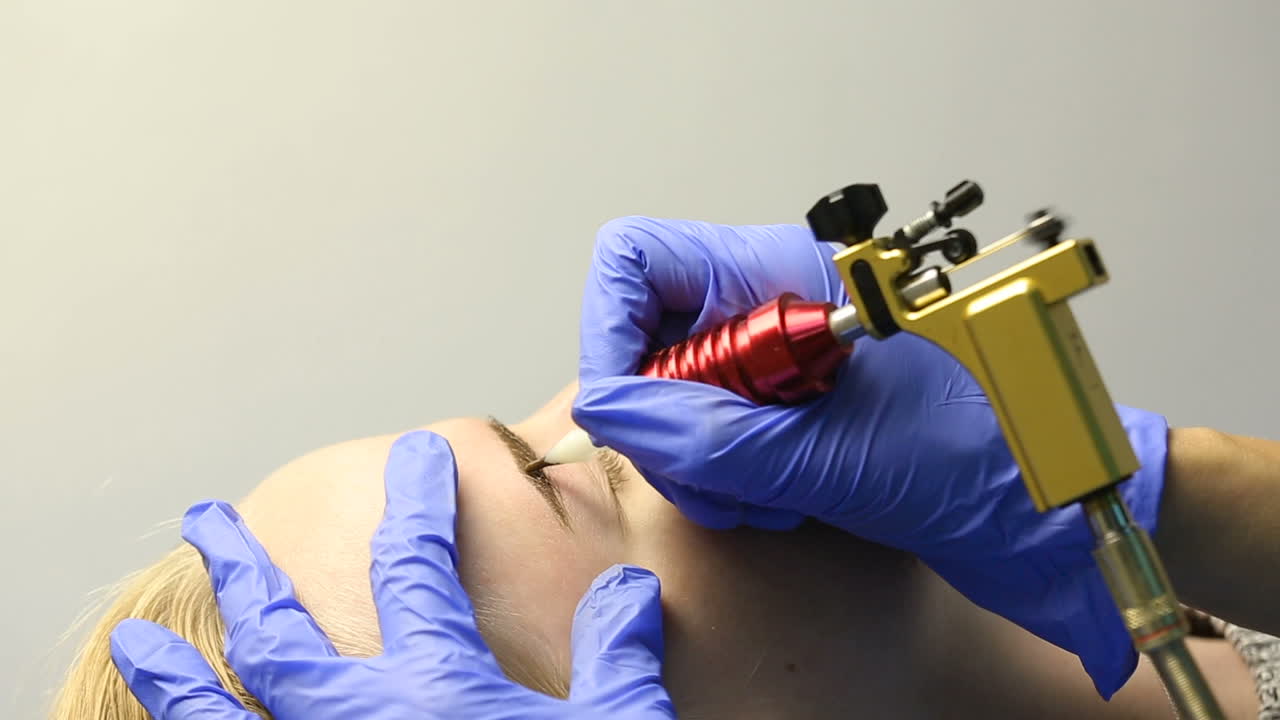 Correction of eyebrows. Young woman having permanent makeup eyebrow in beautician salon