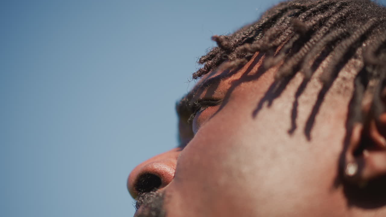 Determined Individual Standing With Confidence Outdoors, Steadfast Figure Observing Horizon Under Bright Sunlight, An Unwavering Guardian With Strong Demeanor Gazing Into Expansive Blue Sky
