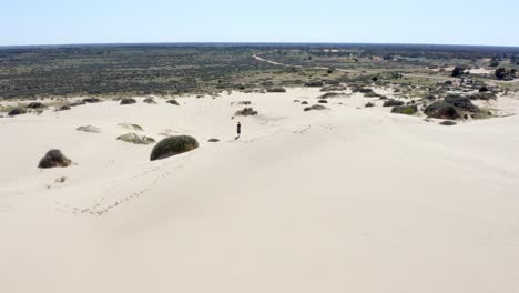 girl exploring huge sand dunes in an australian desert on a hot bright sunny day, aerial shot 3