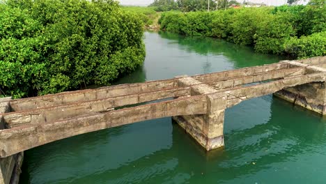 a 4k aerial shot of an ancient bridge on a river