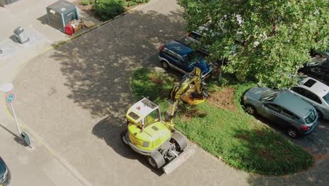 tractor-with-mowing-arm-cuts-through-bushes-in-a-residential-area