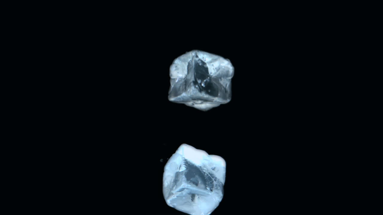 dos cubos de hielo cayendo sobre un fondo negro