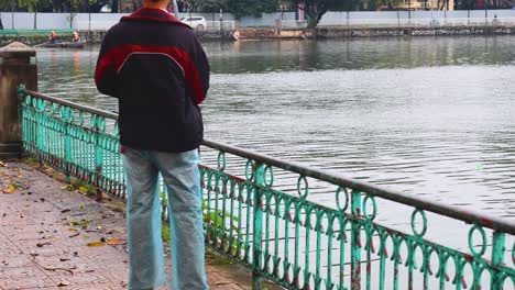 person fishing at a pond in hanoi, vietnam