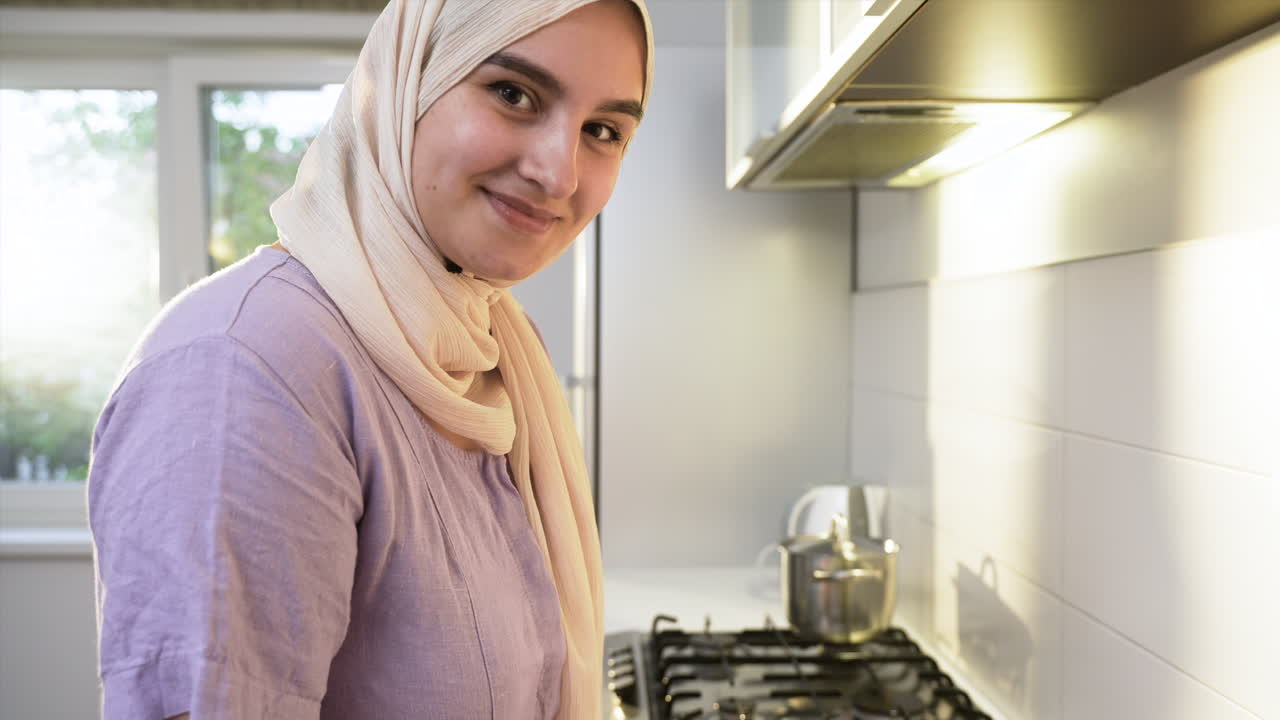 mujer islámica con hijab en la cocina.