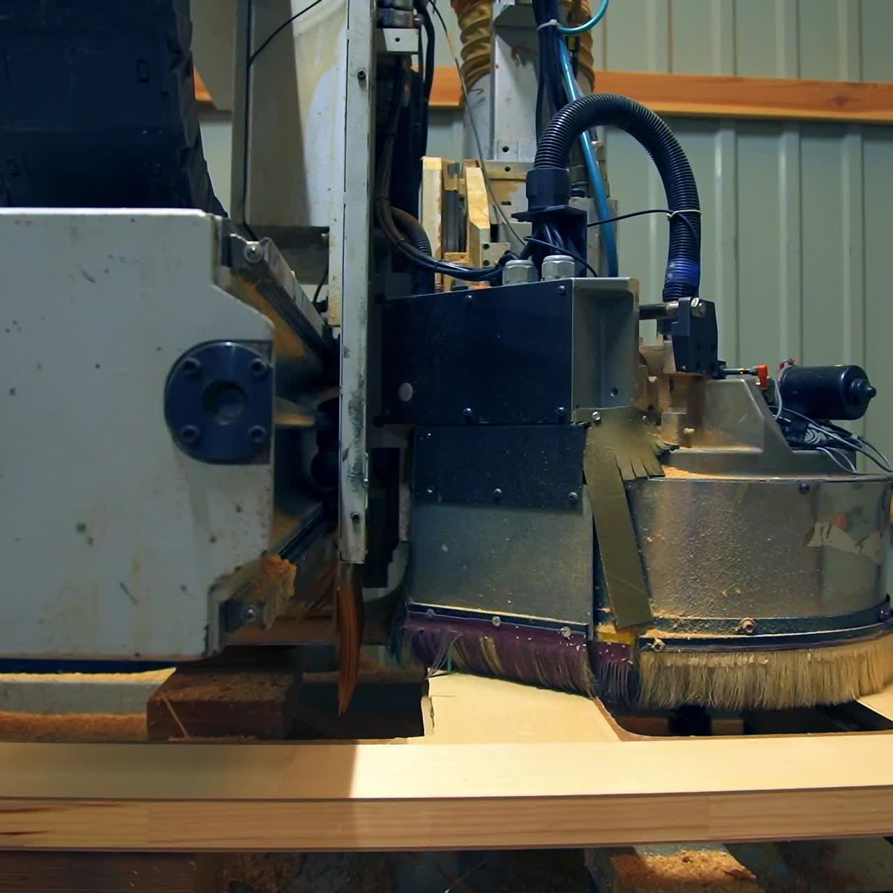 Polishing the wooden part of the future door. Automatic tool machine moves over the surface of timber plank