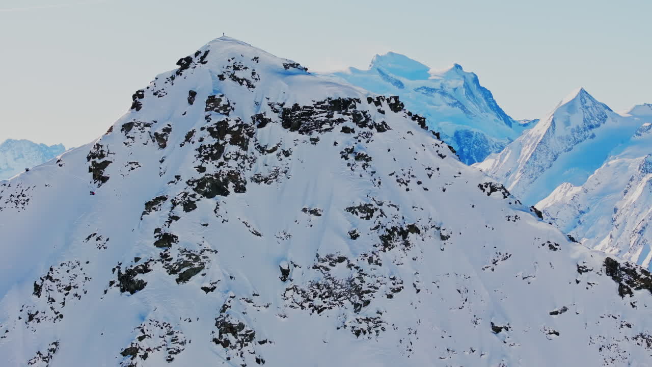 Ski mountaineers atop Bec des Rosses, Val de Bagnes, with Grand Combin behind, ready to drop into the legendary north face.
