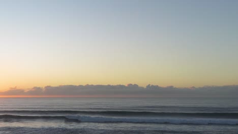 calm ocean waves under a vibrant sunrise sky at gold coast, australia. soft lighting enhances the tranquil atmosphere