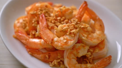 fried shrimps or prawns with garlic on white plate - seafood style