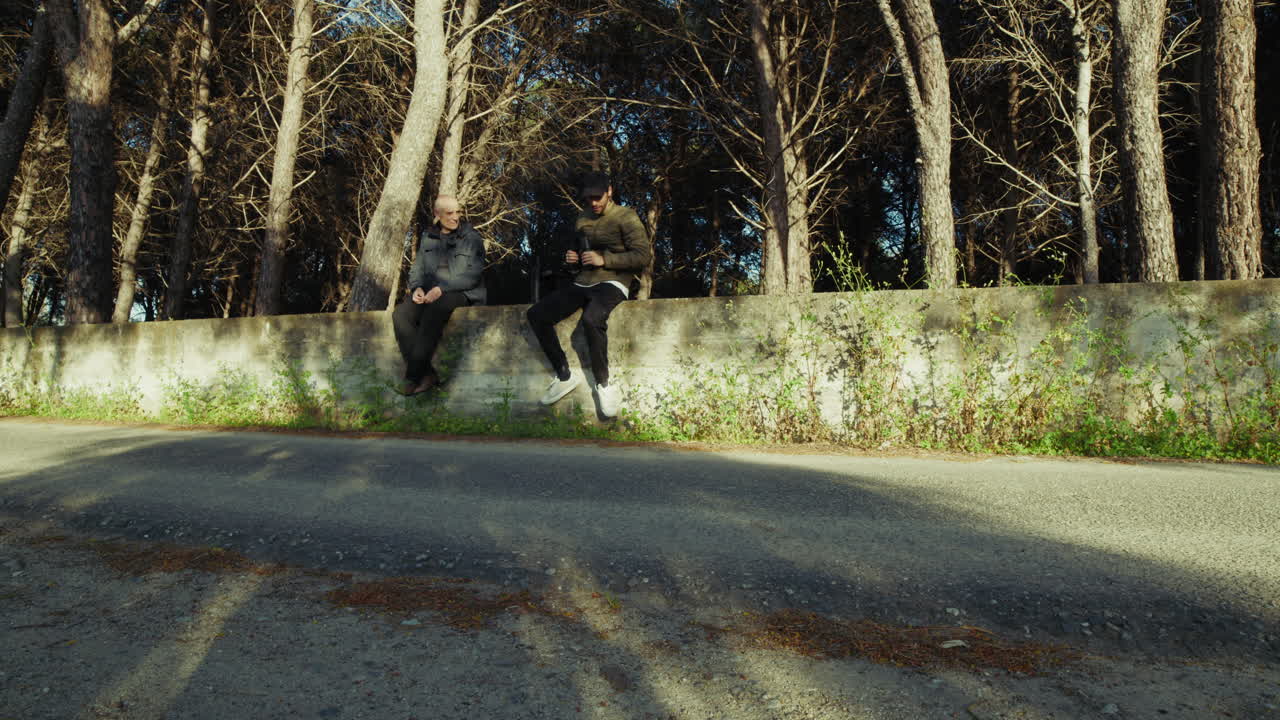Elderly Father and Son Contemplate the Landscape in a Mountain Forest