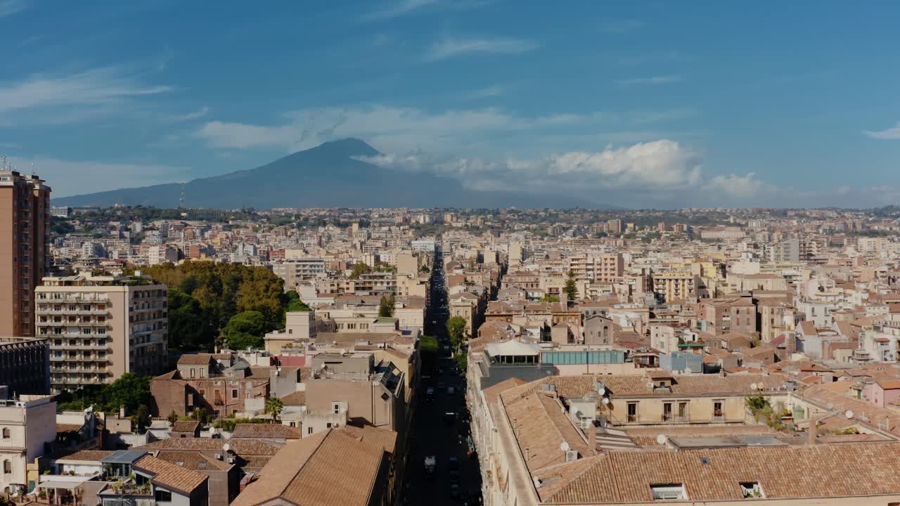 Flying towards most active volcano in Europe. Aerial view of Mount Etna above Catania's main street. UNESCO World Heritage. Sicily. Italy.