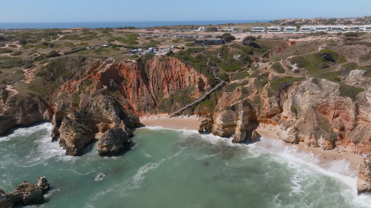 Escaleras guían a los turistas a la playa aislada de Praia da Dona Ana, Algarve, vista aérea panorámica.