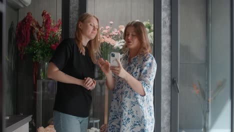 Two women browsing flowers in a shop