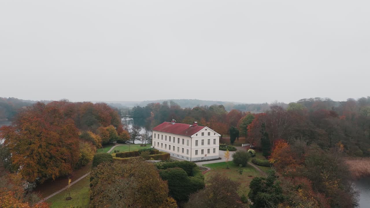 Gyllebo lake in South Sweden, Skåne, Österlen at Autumn with yellow and orange leafs, mansion, fog mansion