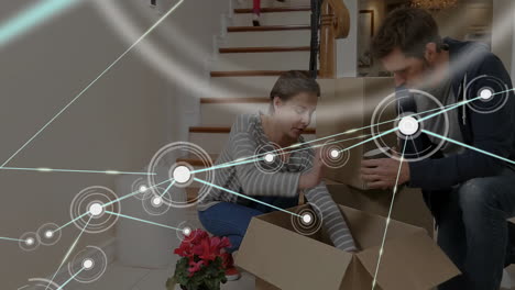 network of connections animation over people unpacking boxes in new home