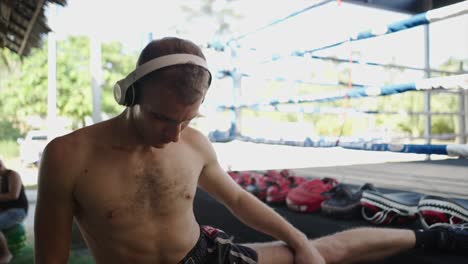 athlete stretching in a boxing gym with headphones