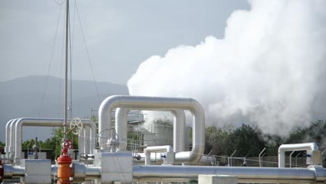 geothermal station with steam and pipes in the rainforest. billowing steam from smoke stack filling sky, super slow motion close up. buharkent, turkey