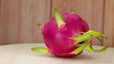 dragon fruit rotates on a wooden surface