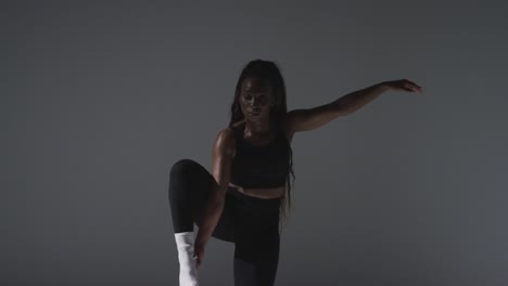 full length studio shot of woman wearing gym fitness clothing doing stretching exercise 5