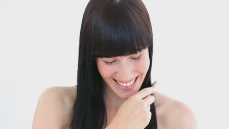 una morena sonriente usando un peine