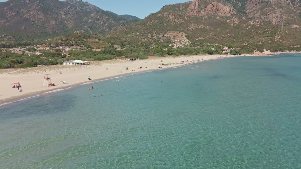 Fly Drone Slide View of Tropical Sea with People and Umbrellas at Beach