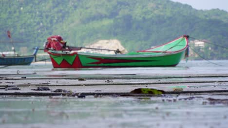 footage of a long tail boat at a beach in phuket, thailand