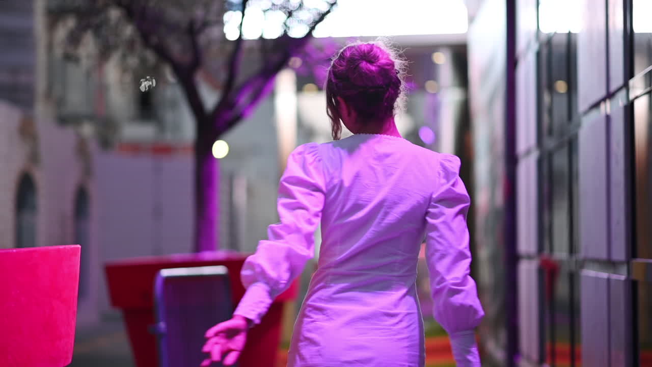 Woman in white dress posing in Cannes in purple lights, France