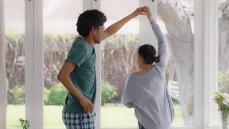 happy father dancing with teenage daughter having fun enjoying playful dance enjoying weekend celebration at home wearing pajamas