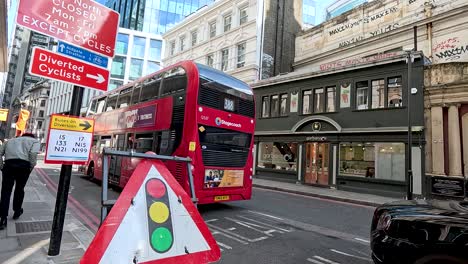 red bus passing street signs in london