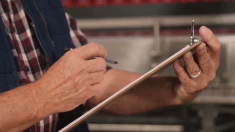 male worker maintaining records on clipboard