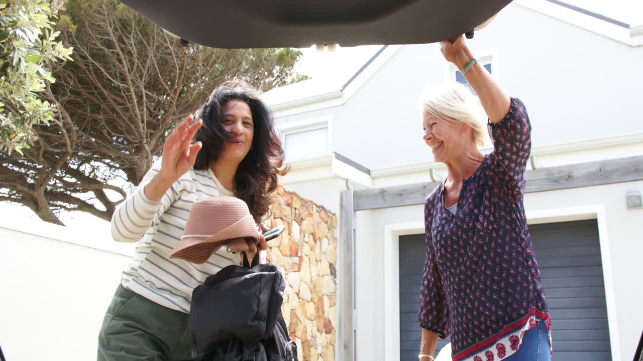 두 명의 행복한 다양한 고령 여성이 차 트크를 열고 은 날 배을 놓고, 느린 동작