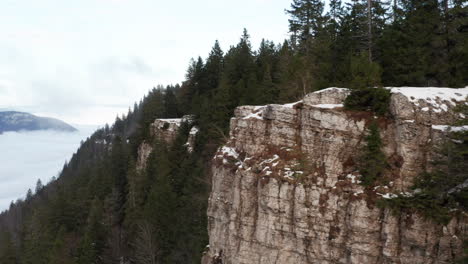 Aerial-of-forest-covered-mountain-ridge-with-low-hanging-clouds-in-valley