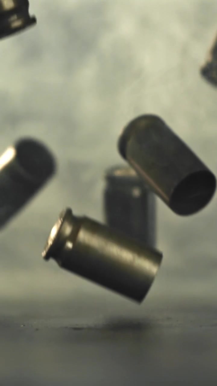 Bullet Casings Falling in Slow Motion Against Smoky Background
