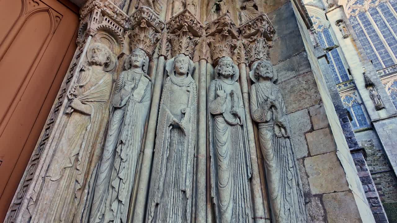 Detailed medieval stone sculptures of saints at Gothic portal of Le Mans Cathedral, France