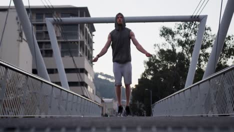 sportlicher kaukasischer mann trainiert auf einer brücke