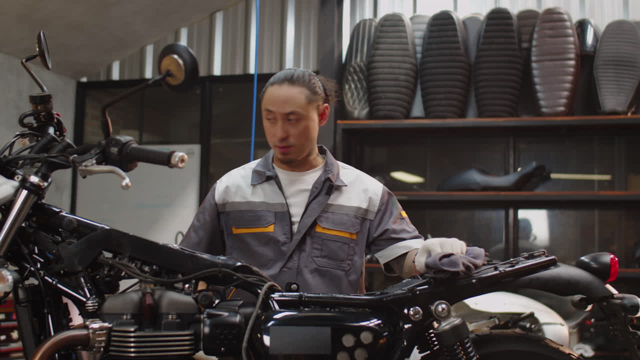 Multicultural Repairman Examining Motorbike Components