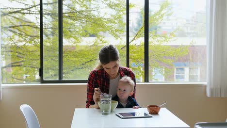 mother feeding breakfast to her baby 4k