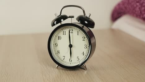 Alarm-Clock-Standing-on-The-Wooden-Table-in-the-Bedroom