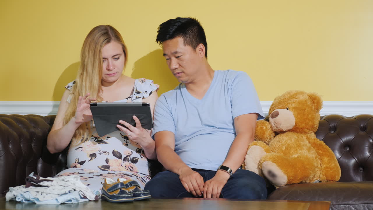 아기를 기대하는 젊은 부부 - 미래의 아기를 위해 즐거운 구매를 주문하십시오